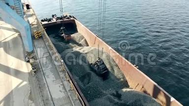 一辆起重机从驳船上抓起瓦砾堆成一堆。